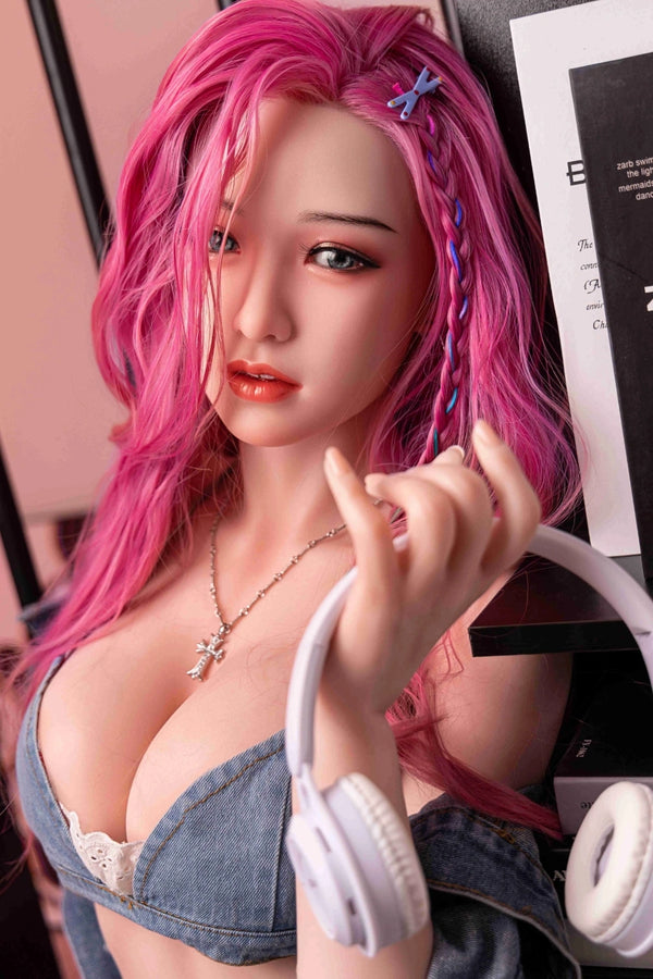 Sex doll with pink hair and denim outfit in a blurred indoor setting