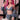 Person with pink hair wearing a denim outfit holding a book.