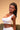 Woman wearing a white top against a beige background