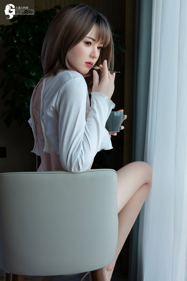 Woman sitting on a chair holding a glass of water indoors.