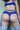 Person wearing blue lingerie with a visible brand logo on a neutral background