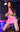 Figure in a pink outfit with fishnet stockings on a reflective surface.