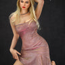 A highly realistic beige sex doll with long blonde hair, posed in a pink dress. The doll has a lifelike appearance with detailed facial features and a flexible skeleton, designed for versatile posing.