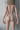 Naked person standing against a neutral background with 'Nudist' branding.