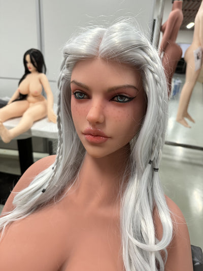 A realistic sex doll with Silver hair, in nude The doll has a lifelike appearance with detailed features, including a prominent bust and curves.