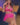 Figure in a pink outfit with fishnet stockings on a chair.