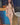 Figure standing nude against a blue background.